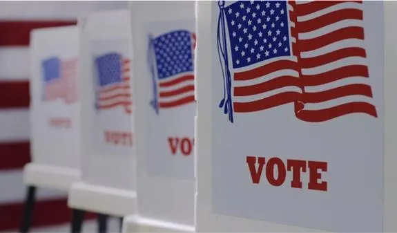 A row of voting booths with the word "Vote" and the American flag printed on the side